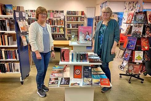 Biblioteksjef og bibliotekmedarbeidar fotografert framfor noko av bokinnhaldet i Hyllestaf folkebibliotek - Klikk for stort bilete