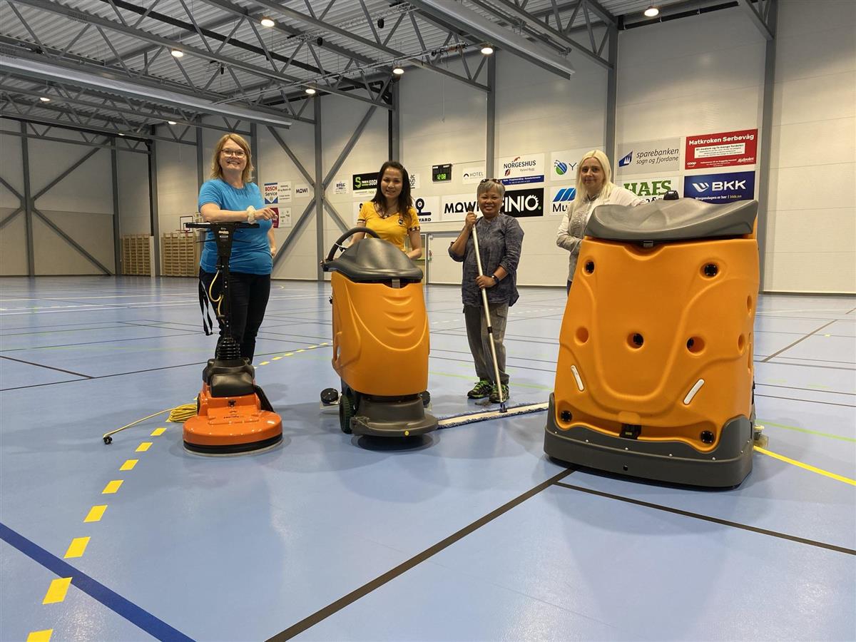 Fire av reinhaldarane i Hyllestad kommune med vaskereiskap i Hyllestadhallen. - Klikk for stort bilete